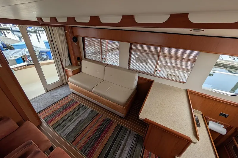 Slide: The Image of Interior of 2008 Mainship 38 yacht with sofa, striped rug, and large windows. - 14