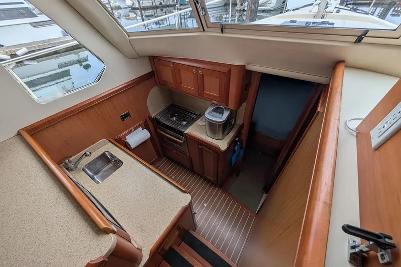 Slide: The Image of 2008 Mainship 38 yacht interior kitchen with wood cabinetry and modern appliances. - 16