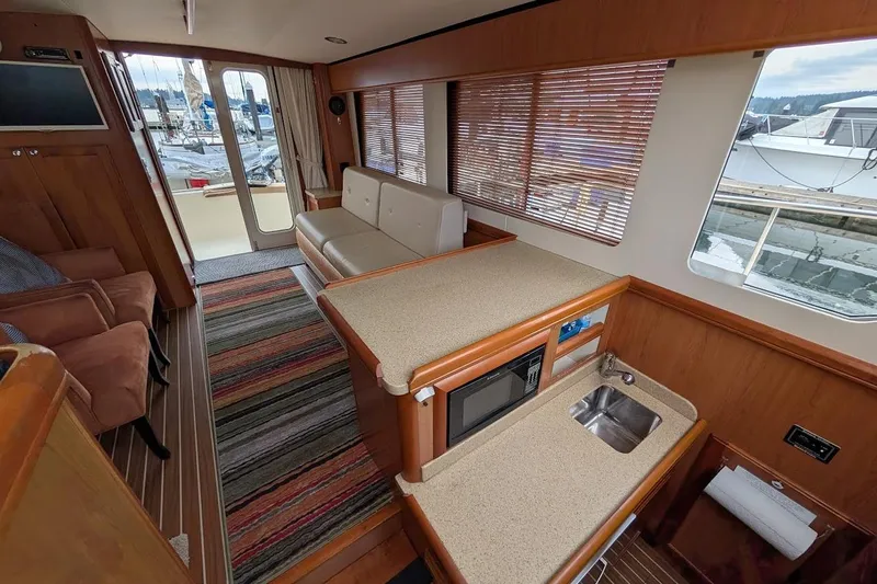 Slide: The Image of Interior of a 2008 Mainship 38 yacht with modern kitchen and seating area. - 18