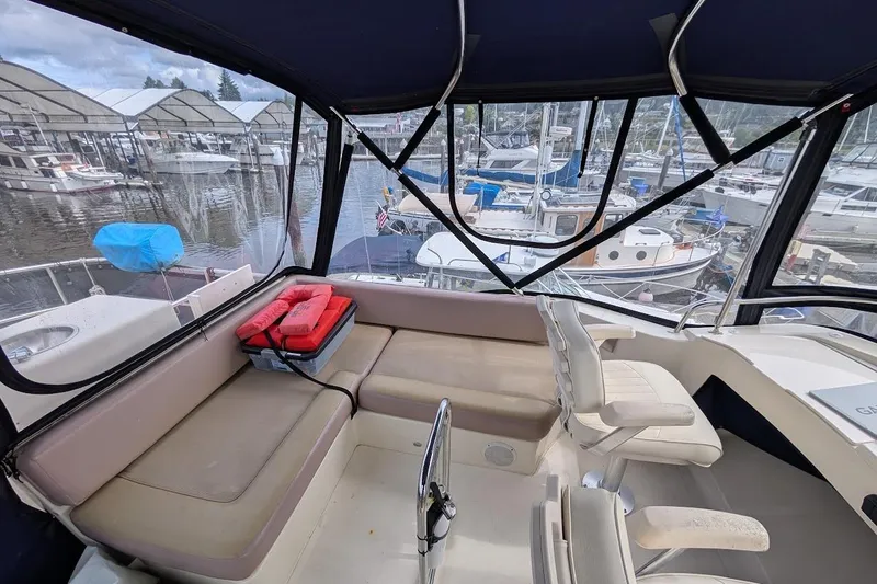 Slide: The Image of 2008 Mainship 38 boat interior with seating, marina view, and protective canopy. - 26