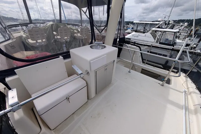 Slide: The Image of 2008 Mainship 38 boat deck with seating and storage, docked at marina. - 27