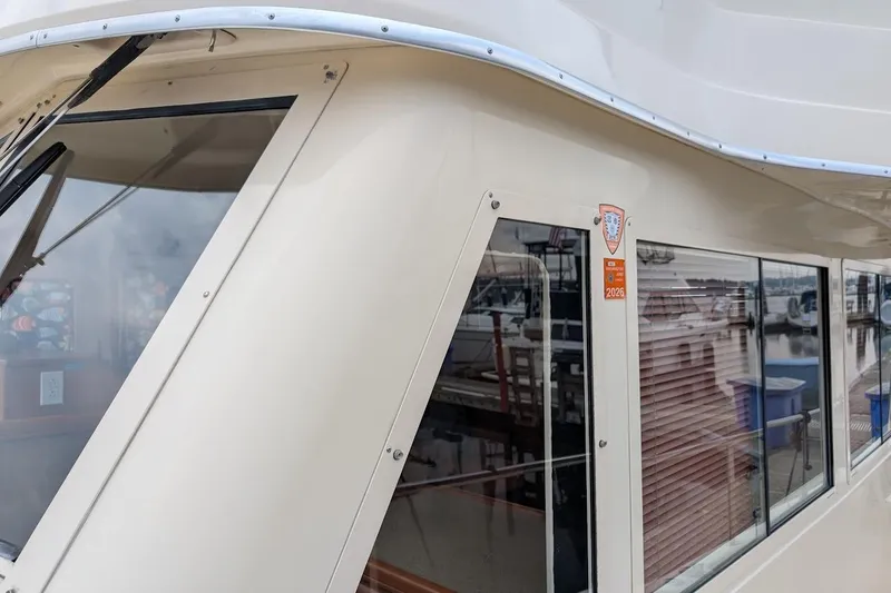 Slide: The Image of 2008 Mainship 38 boat exterior with windows and marina reflection. - 3