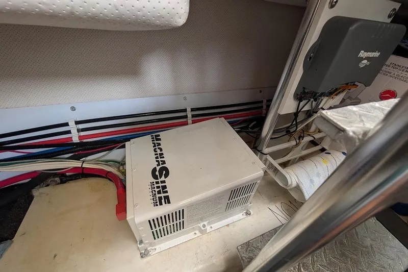 Slide: The Image of Electrical components and wiring inside a 2008 Mainship 38 boat, featuring a Magnum inverter. - 30