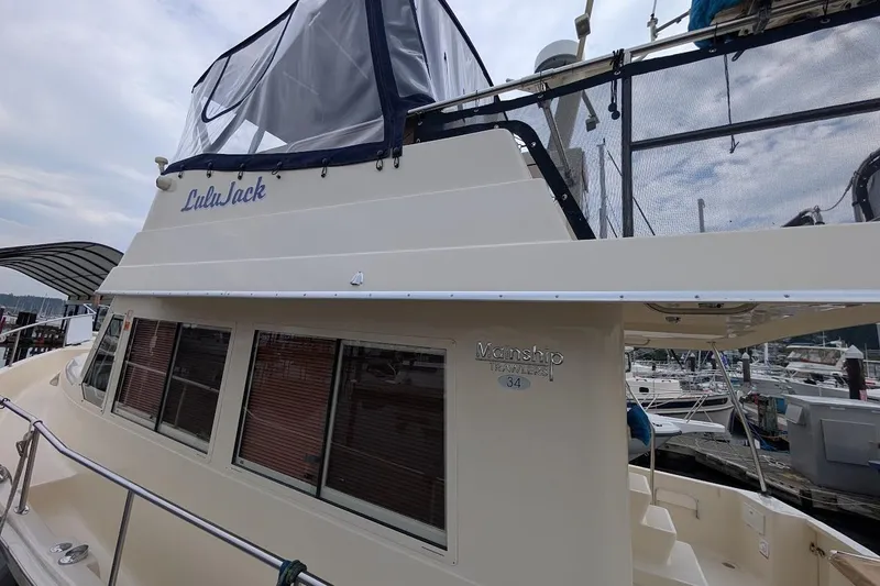 Slide: The Image of 2008 Mainship 38 boat docked at marina, featuring upper deck enclosure. - 4