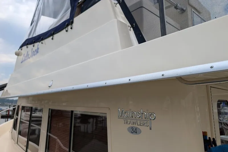 Slide: The Image of 2008 Mainship 38 boat with "Mainship Trawlers 34" emblem, docked at marina. - 7