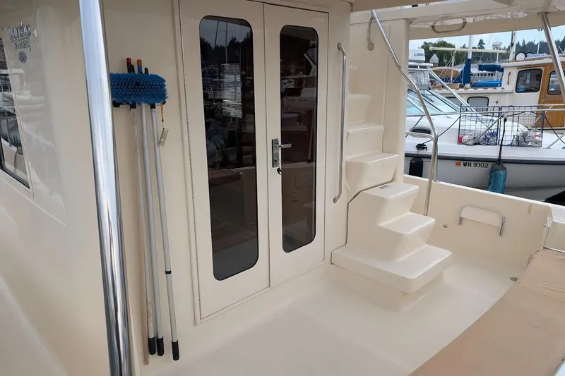 Slide: The Image of 2008 Mainship 38 boat deck with stairs and glass doors, docked at marina. - 9