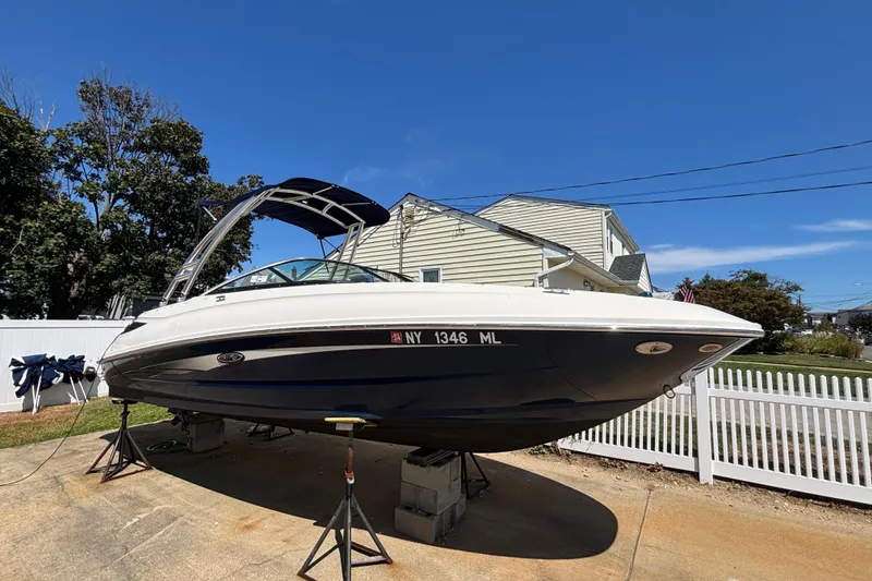 The Image of 2015 Sea Ray 240 Sundeck boat on stands, in a residential driveway. - 0