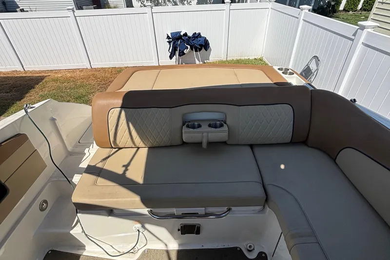 Slide: The Image of 2015 Sea Ray 240 Sundeck boat interior with cushioned seating and cup holders. - 11