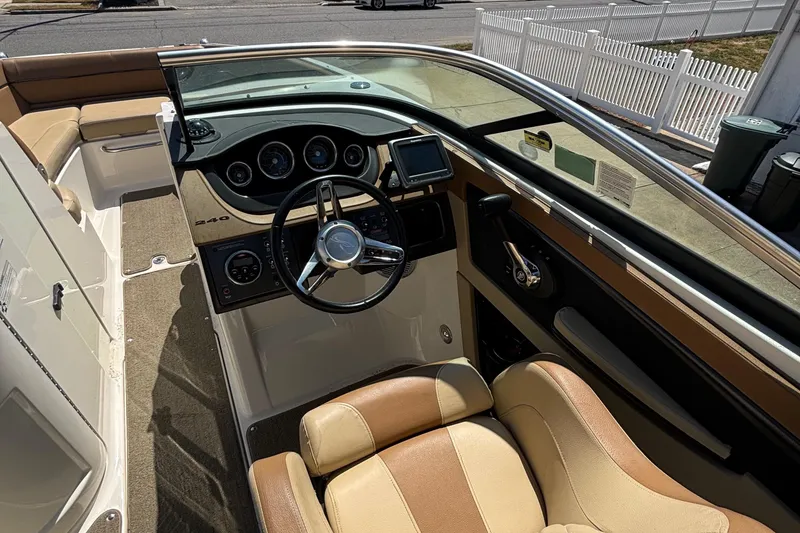 Slide: The Image of 2015 Sea Ray 240 Sundeck interior with steering wheel and dashboard controls. - 15