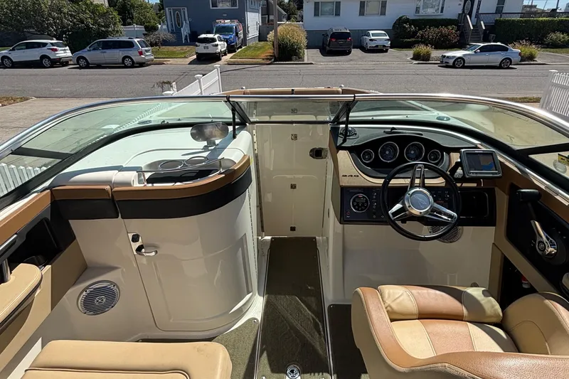 Slide: The Image of 2015 Sea Ray 240 Sundeck interior with steering wheel, dashboard, and seating. - 18