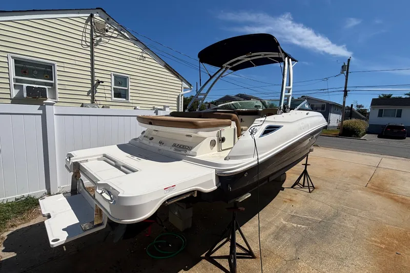 Slide: The Image of 2015 Sea Ray 240 Sundeck boat on stands in residential driveway. - 2