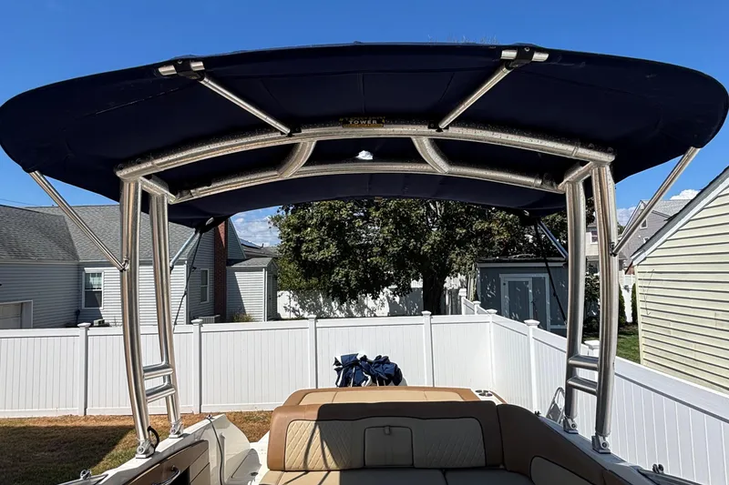 Slide: The Image of 2015 Sea Ray 240 Sundeck boat with canopy, parked in a residential backyard. - 21