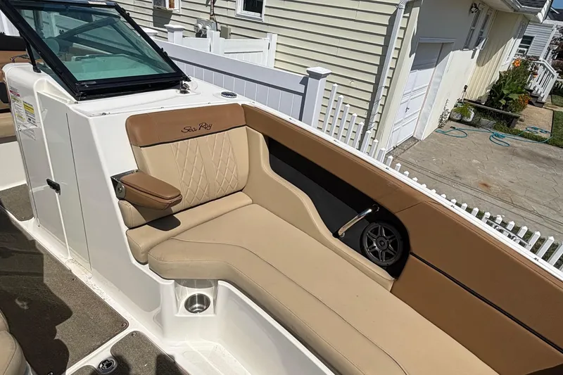 Slide: The Image of 2015 Sea Ray 240 Sundeck interior with tan seating and speaker detail. - 23