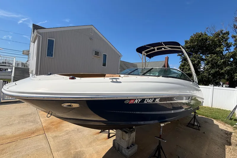 Slide: The Image of 2015 Sea Ray 240 Sundeck boat on blocks, parked in a residential driveway. - 3