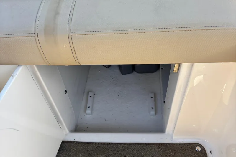 Slide: The Image of 2015 Sea Ray 240 Sundeck storage compartment with beige seating and white interior. - 35
