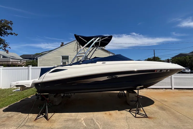 Slide: The Image of 2015 Sea Ray 240 Sundeck boat on stands, residential background, clear sky. - 37