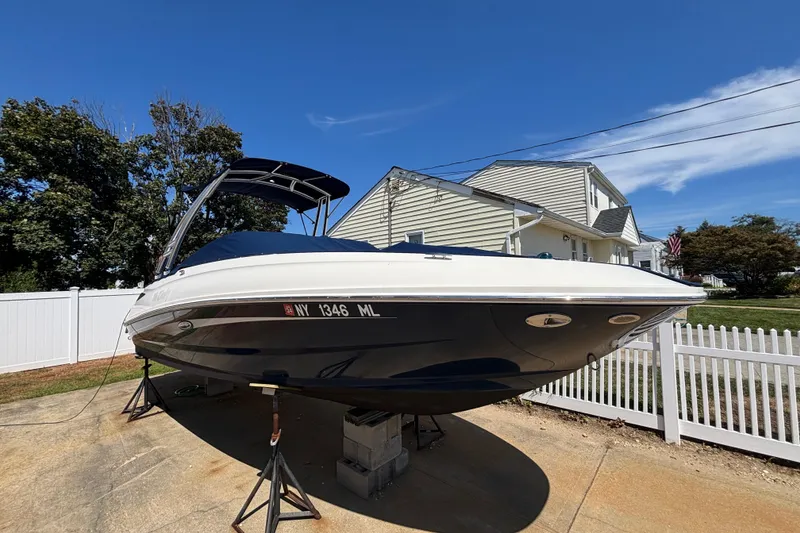 Slide: The Image of 2015 Sea Ray 240 Sundeck boat on stands, residential background, clear sky. - 38