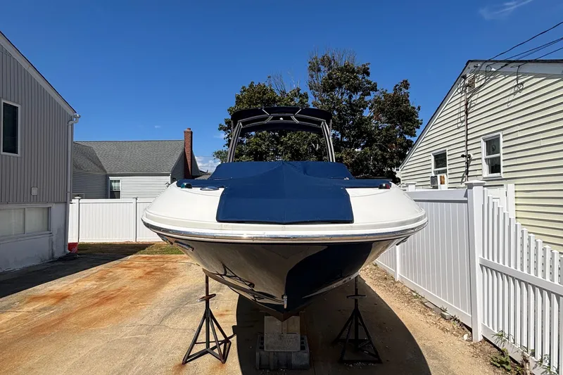 Slide: The Image of 2015 Sea Ray 240 Sundeck boat on stands, parked between houses. - 39
