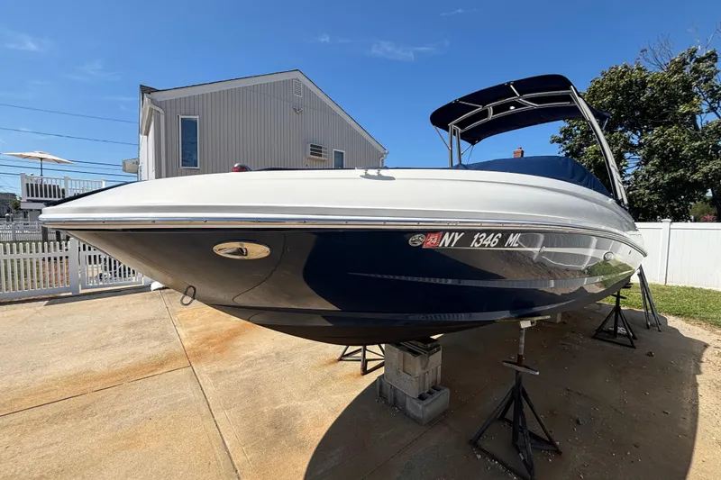 Slide: The Image of 2015 Sea Ray 240 Sundeck boat on stands, parked in a residential driveway. - 40