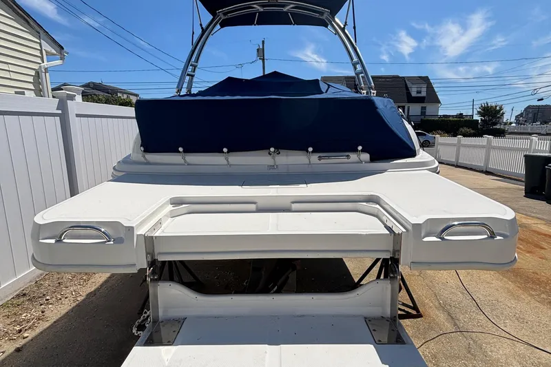 Slide: The Image of 2015 Sea Ray 240 Sundeck boat with blue cover, parked on driveway. - 43