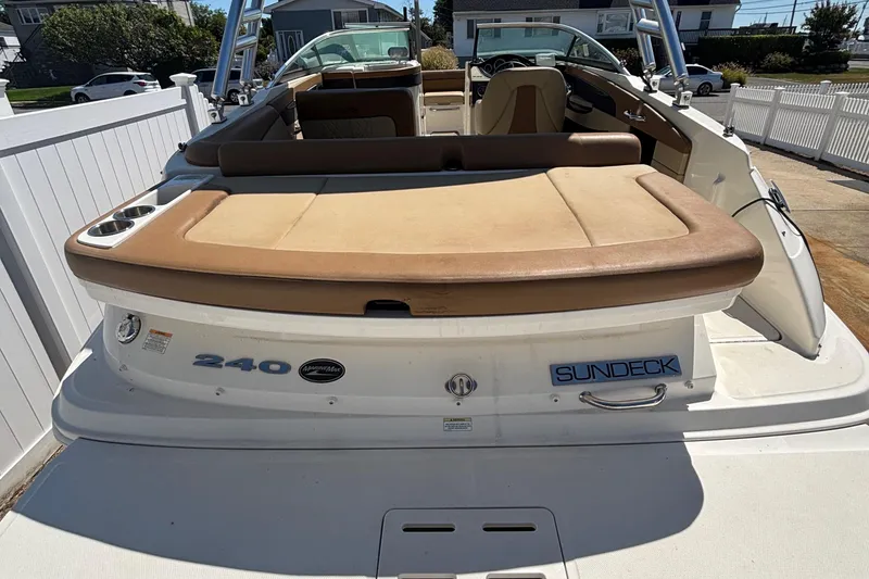 Slide: The Image of 2015 Sea Ray 240 Sundeck boat with tan seating, docked in a sunny residential area. - 6