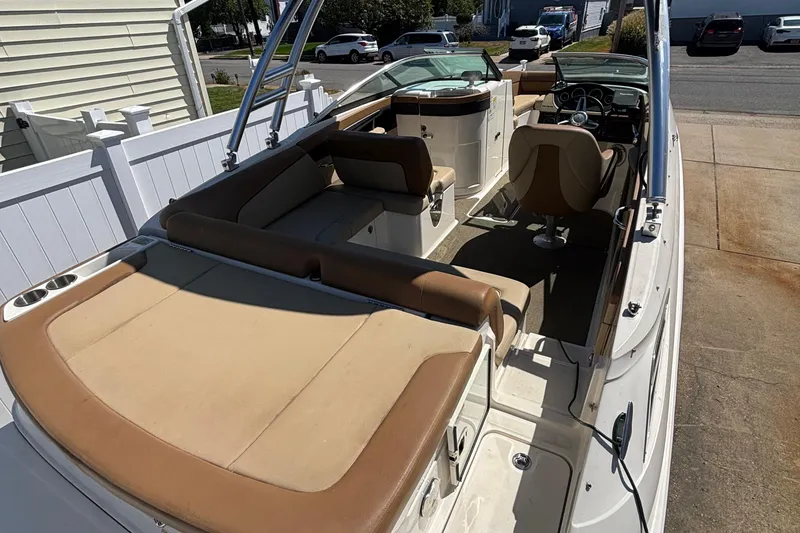 Slide: The Image of 2015 Sea Ray 240 Sundeck boat interior with tan seating and steering wheel. - 9