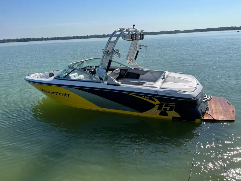 The Image of 2012 MasterCraft X-15 boat on calm lake water, sunny day. - 0