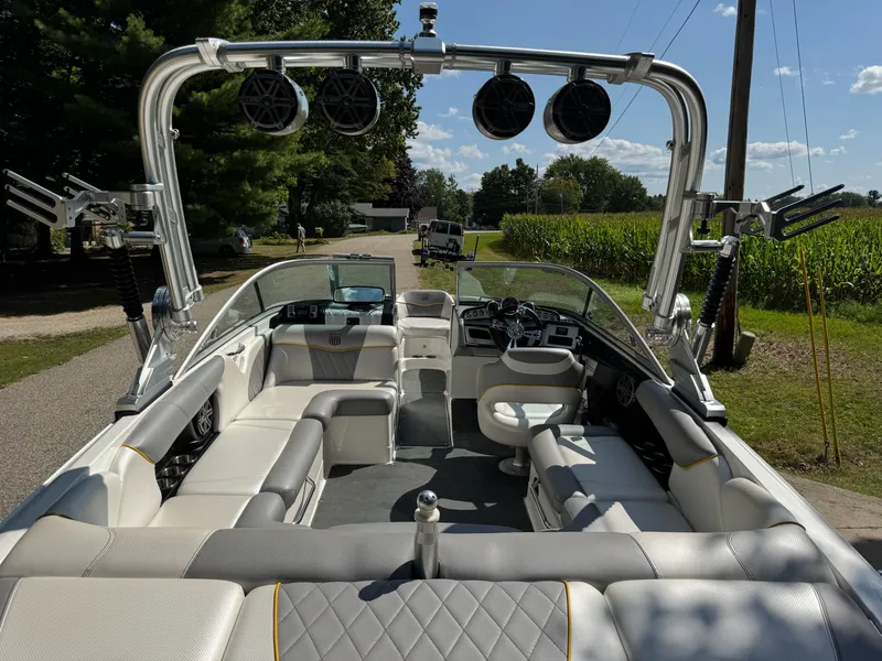 Slide: The Image of 2012 MasterCraft X-15 boat interior with seating and speakers, parked near a cornfield. - 8