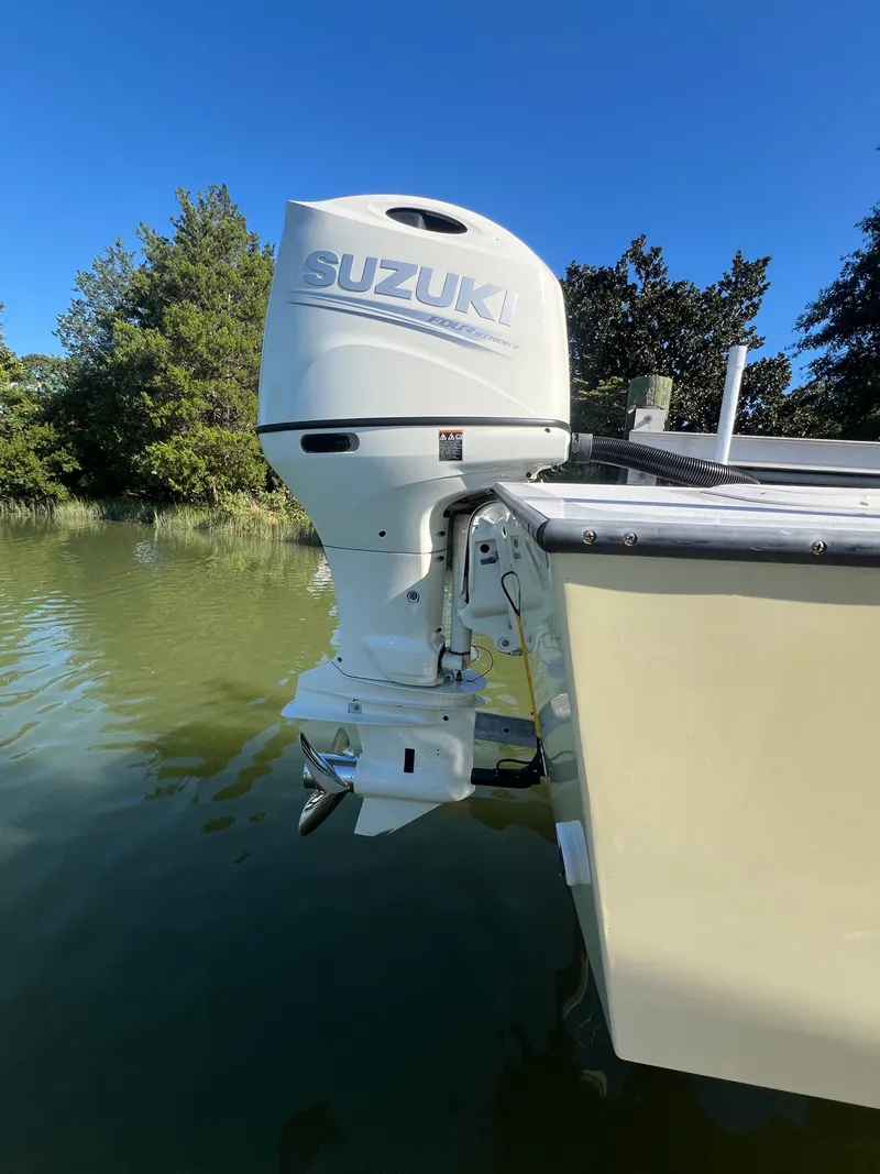 Slide: The Image of Custom 24 boat with Suzuki outboard motor on a calm lake, 2022 model. - 4