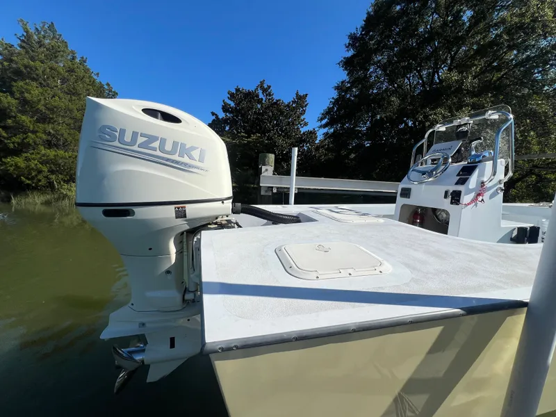 Slide: The Image of Custom 24 boat with Suzuki outboard motor, docked on a sunny day, 2022 model. - 5
