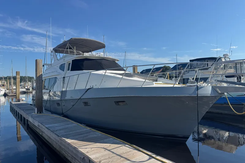 Slide: The Image of 1999 McKinna 57 Pilothouse yacht docked at marina under clear blue sky. - 179