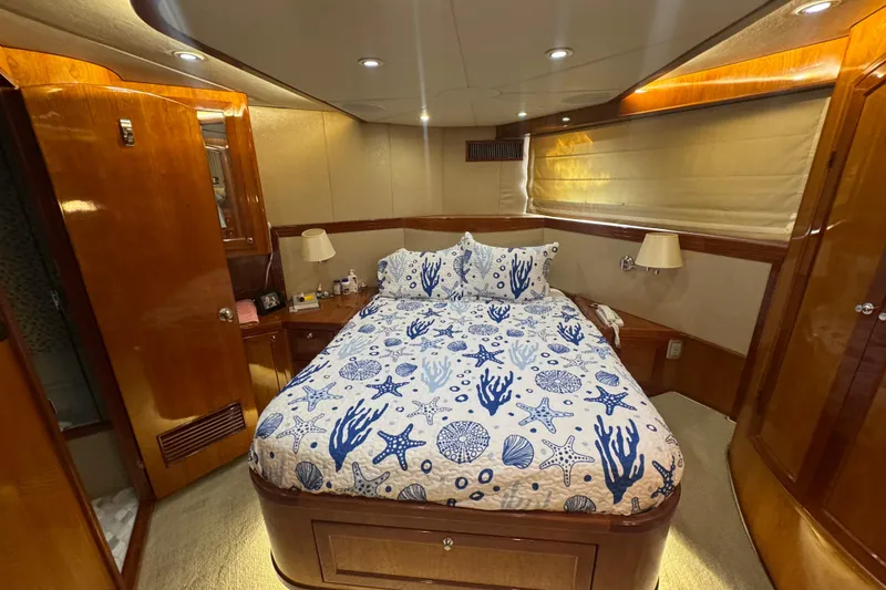 Slide: The Image of Luxurious 1999 McKinna 57 Pilothouse bedroom with nautical-themed bedding and elegant wood finishes. - 185
