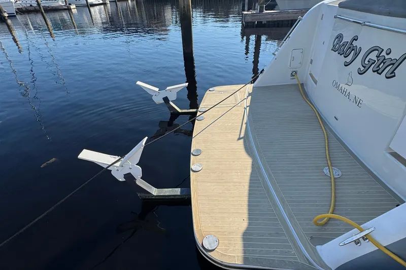 Slide: The Image of 1999 McKinna 57 Pilothouse yacht docked, featuring a spacious deck and mooring equipment. - 203