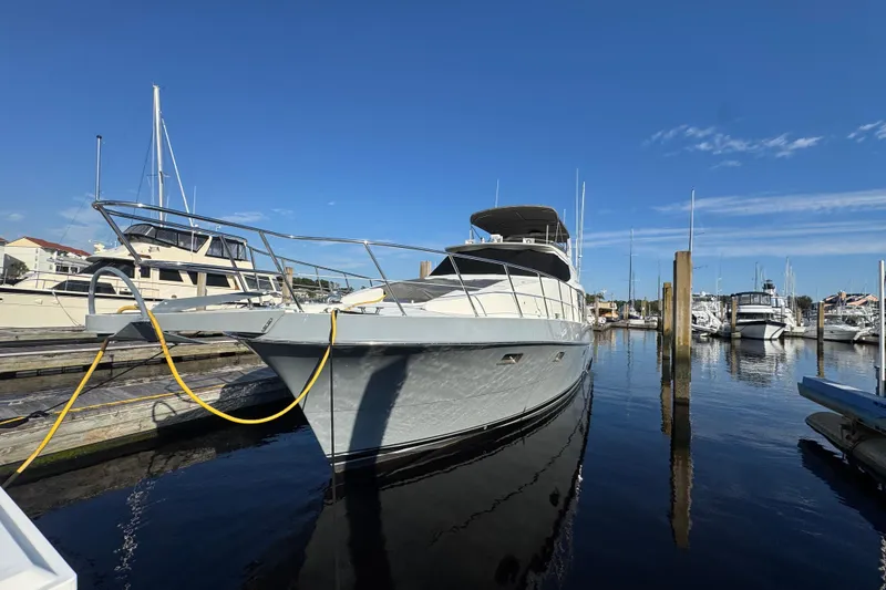 Slide: The Image of 1999 McKinna 57 Pilothouse yacht docked in a marina under clear blue skies. - 204