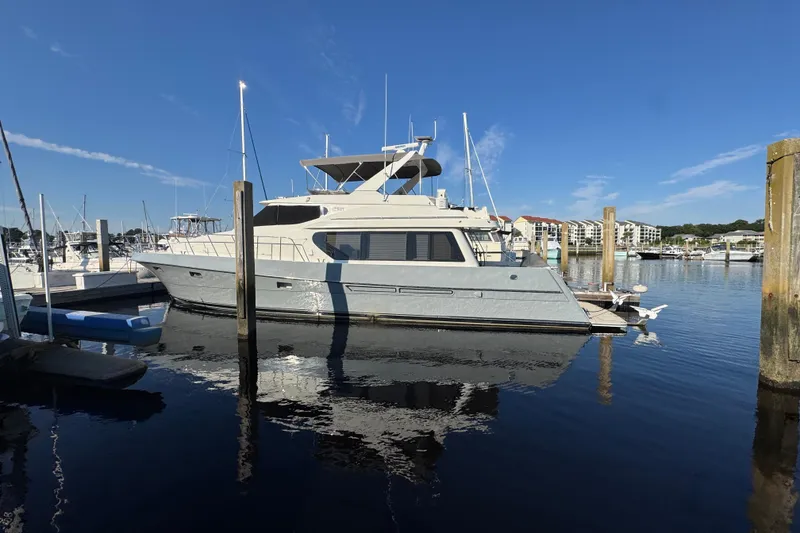 Slide: The Image of 1999 McKinna 57 Pilothouse yacht docked in a marina under clear blue skies. - 206