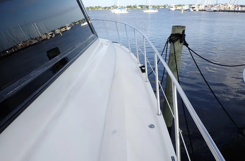 Slide: The Image of 1999 McKinna 57 Pilothouse yacht docked by the water, showcasing sleek deck design. - 21
