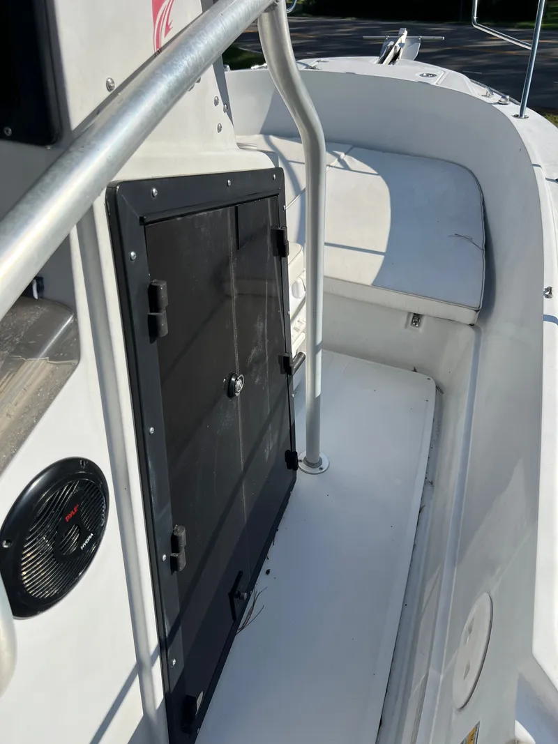 Slide: The Image of The image shows the deck of a 1997 Boston Whaler 24 Outrage with a black door. - 10