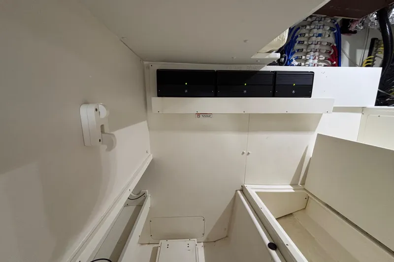 Slide: The Image of 2024 Pursuit OS 445 Offshore interior with electrical panel and storage compartments. - 117