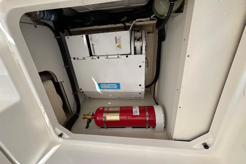 Slide: The Image of 2024 Pursuit OS 445 Offshore engine compartment with fire extinguisher and mechanical components. - 123