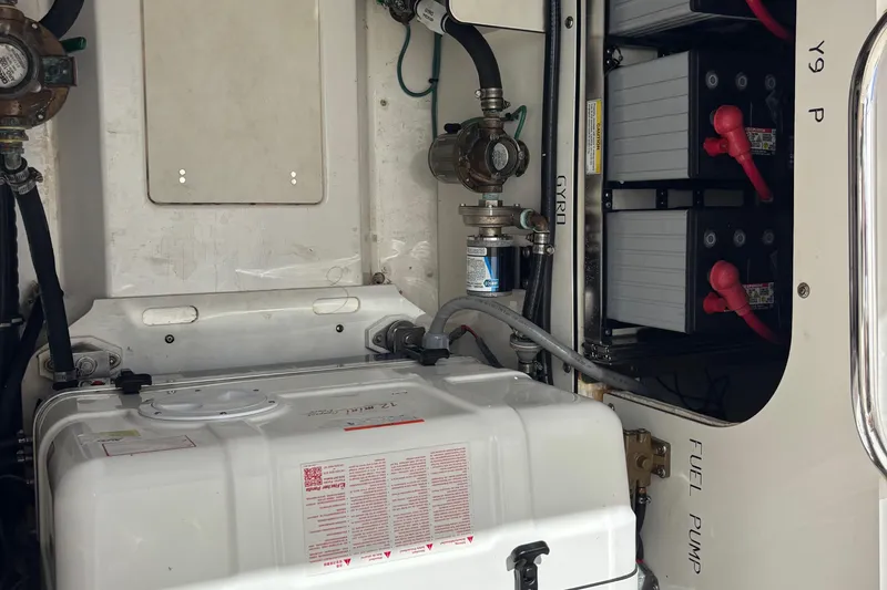 Slide: The Image of 2024 Pursuit OS 445 Offshore engine compartment with batteries and fuel pump. - 125