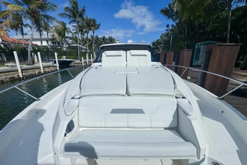 Slide: The Image of 2024 Pursuit OS 445 Offshore yacht with luxurious deck seating, docked by palm trees. - 135