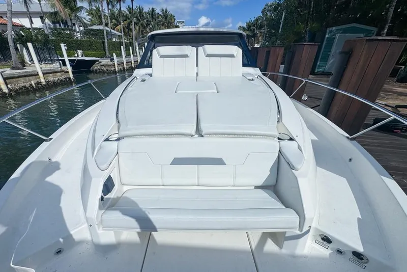 Slide: The Image of 2024 Pursuit OS 445 Offshore boat with white seating, docked near palm trees. - 136