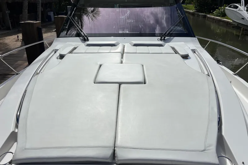 Slide: The Image of 2024 Pursuit OS 445 Offshore boat docked in a serene canal setting. - 15