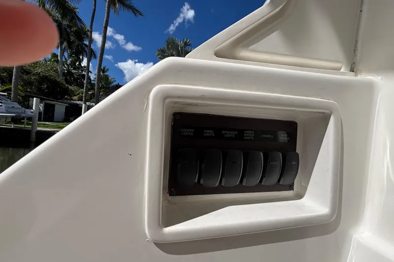 Slide: The Image of 2024 Pursuit OS 445 Offshore boat docked on a serene canal, surrounded by lush palm trees. - 37