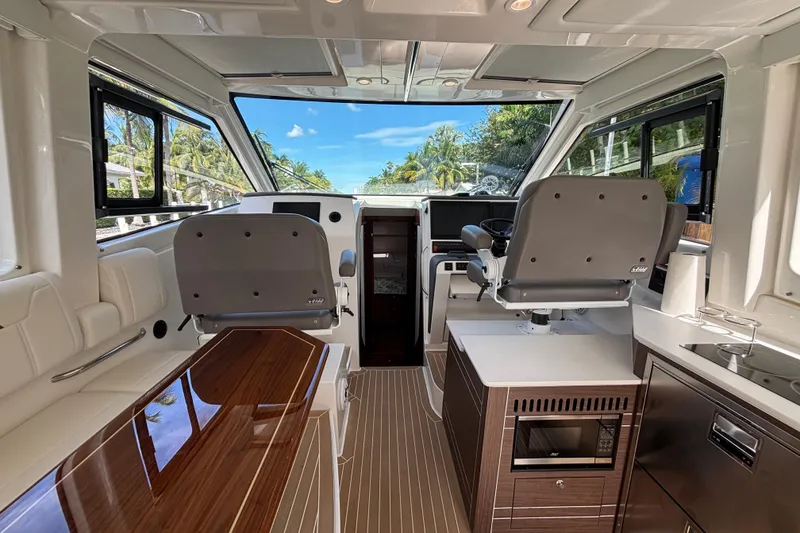 Slide: The Image of 2024 Pursuit OS 445 Offshore interior storage compartment with Kenyon control panel. - 55