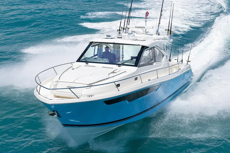 Slide: The Image of 2024 Pursuit OS 445 Offshore boat docked in a scenic waterfront setting. - 6