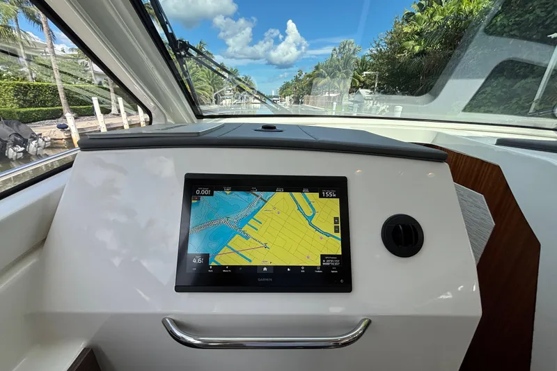 Slide: The Image of 2024 Pursuit OS 445 Offshore boat dashboard with Garmin navigation display. - 77