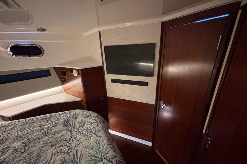 Slide: The Image of 2024 Pursuit OS 445 Offshore boat interior with control panel, speakers, and wooden flooring. - 88