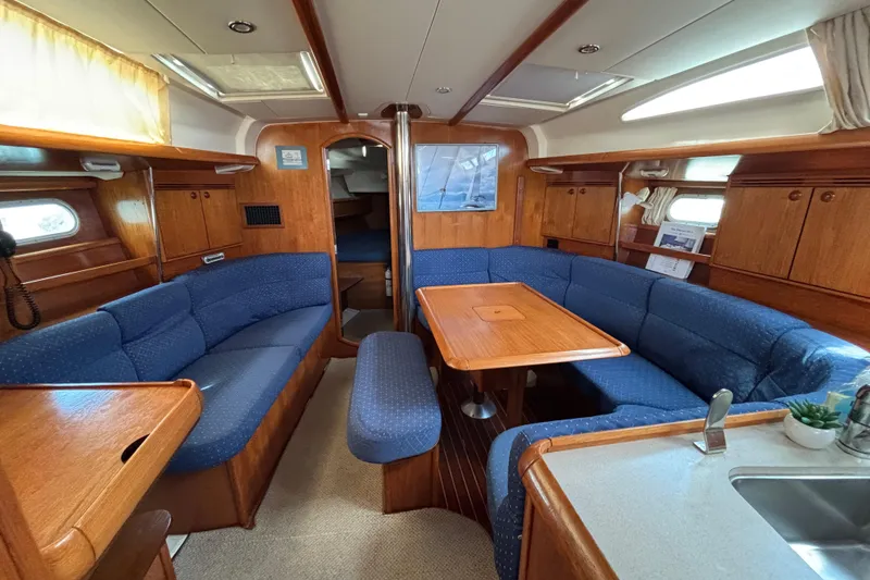 Slide: The Image of Interior of 2004 Jeanneau Sun Odyssey 40.3 sailboat with blue seating and wooden finishes. - 13