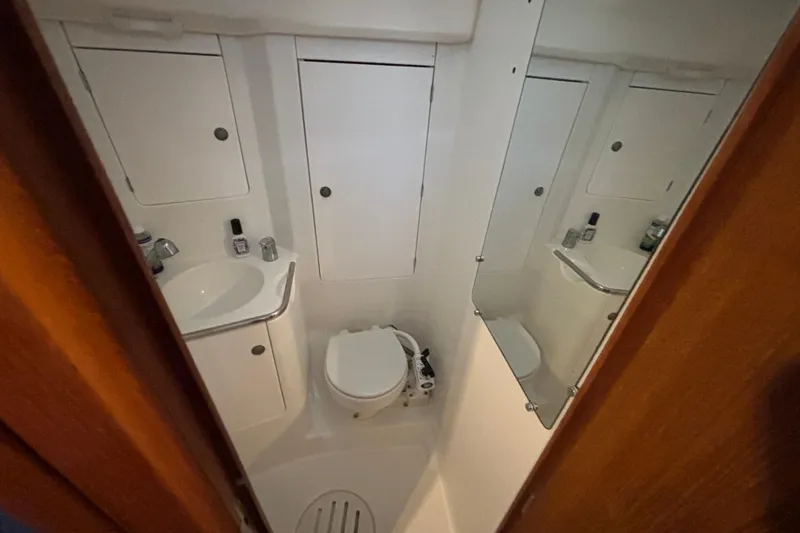Slide: The Image of Bathroom interior of 2004 Jeanneau Sun Odyssey 40.3 yacht, featuring sink, toilet, and mirror. - 21